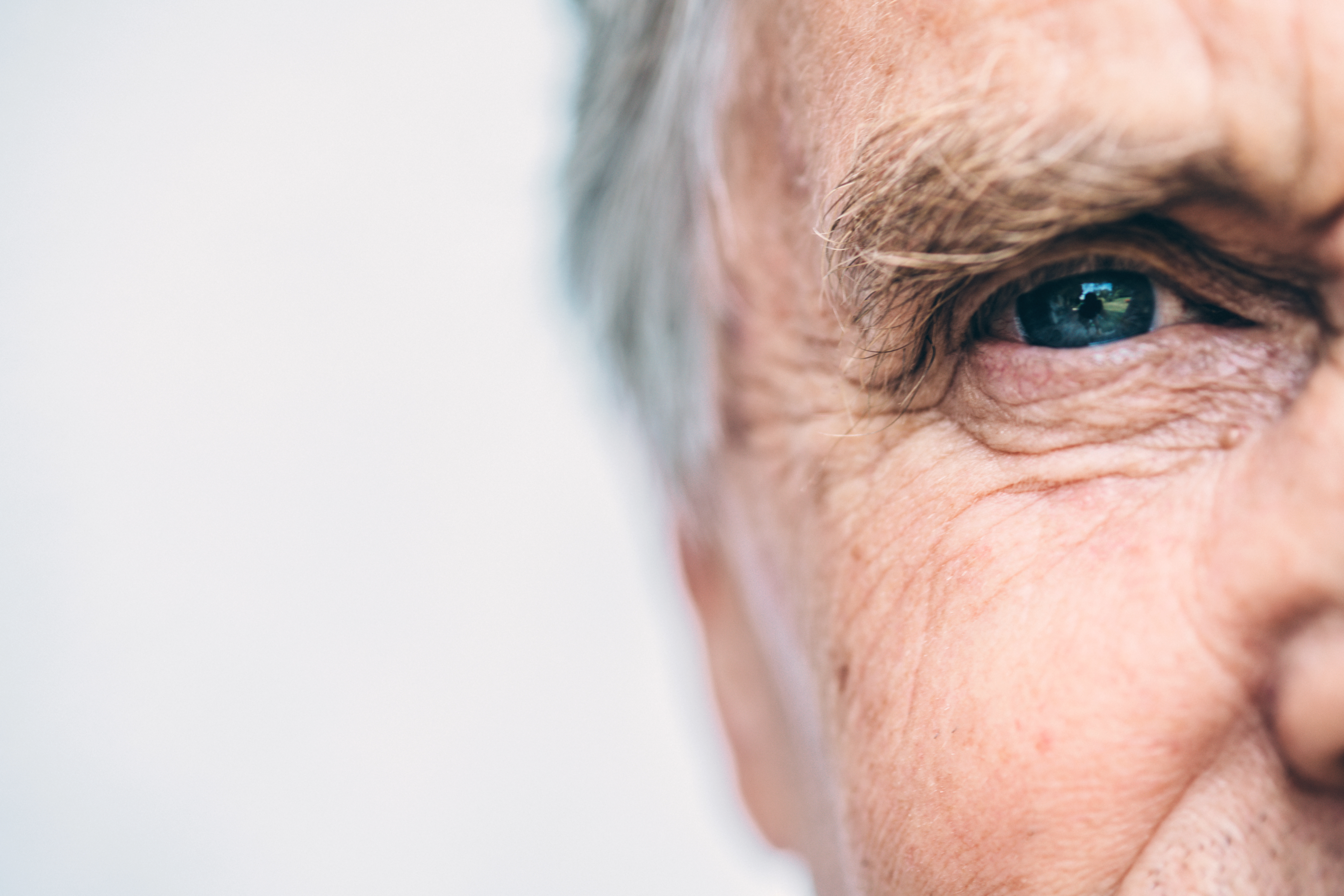 A close up image of an old man looking straight ahead