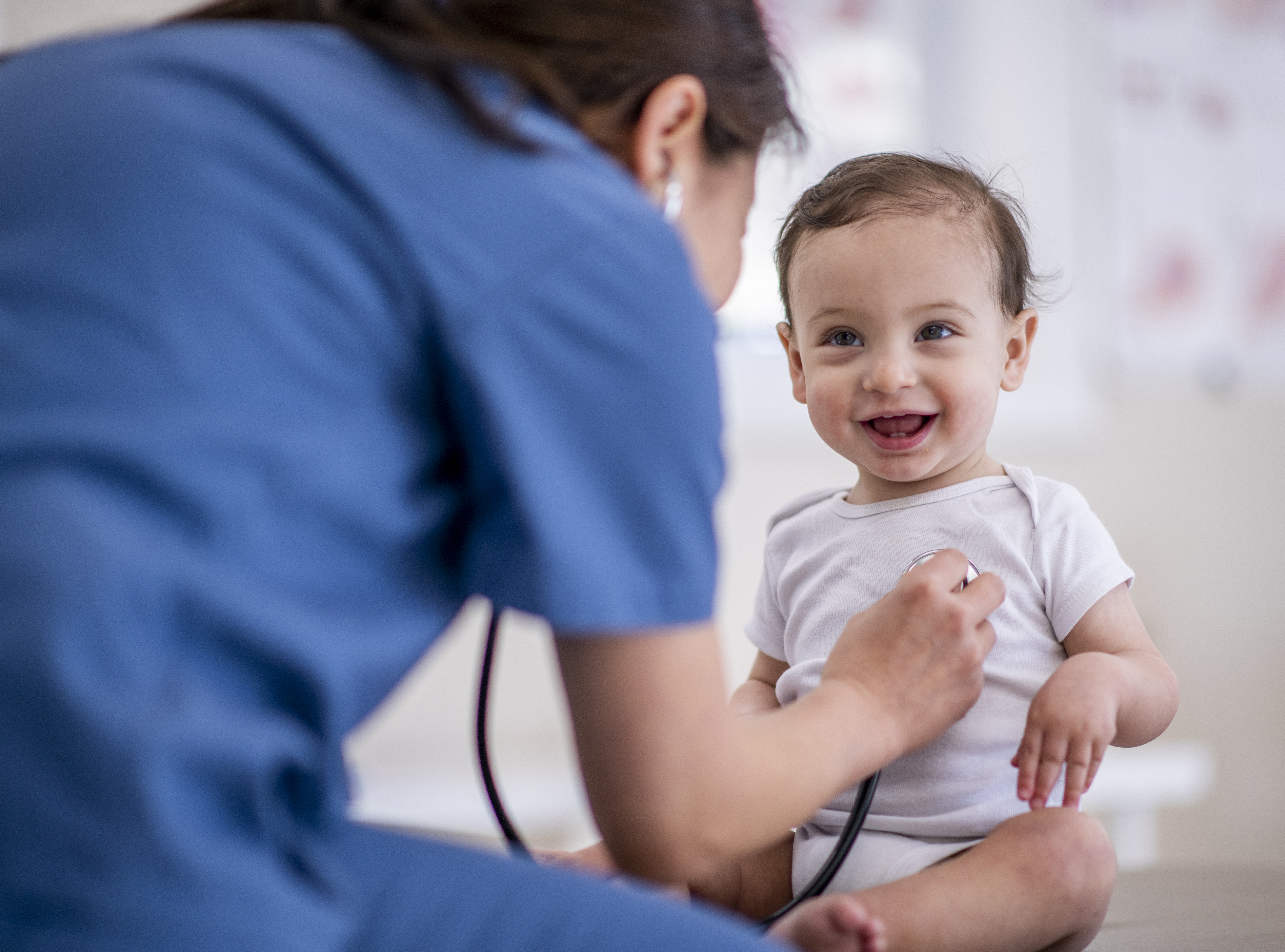 A baby boy being checked by a doctor with a stethoscope 