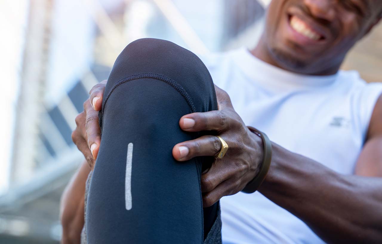 Man needing knee cartilage surgery holds his knee joint in pain