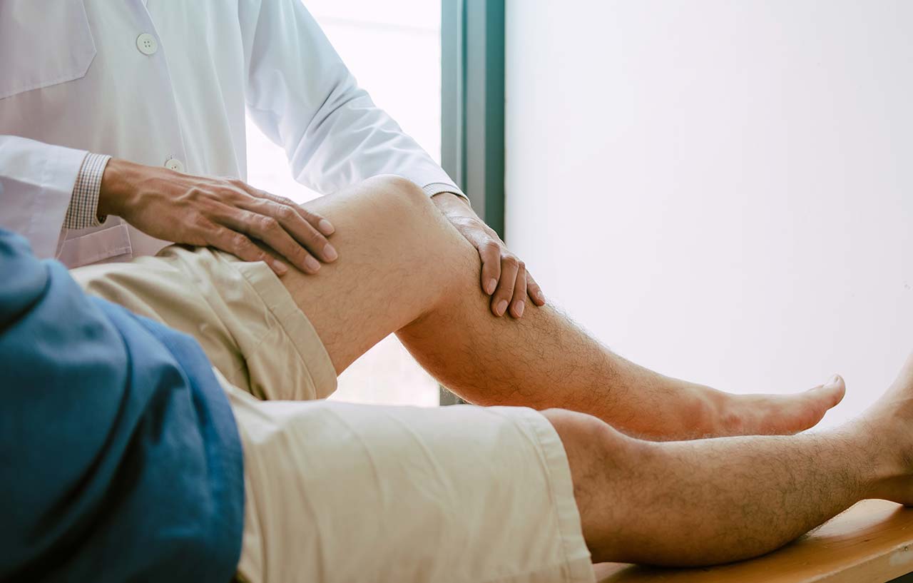 Doctor examining patients knee joint weeks following surgery