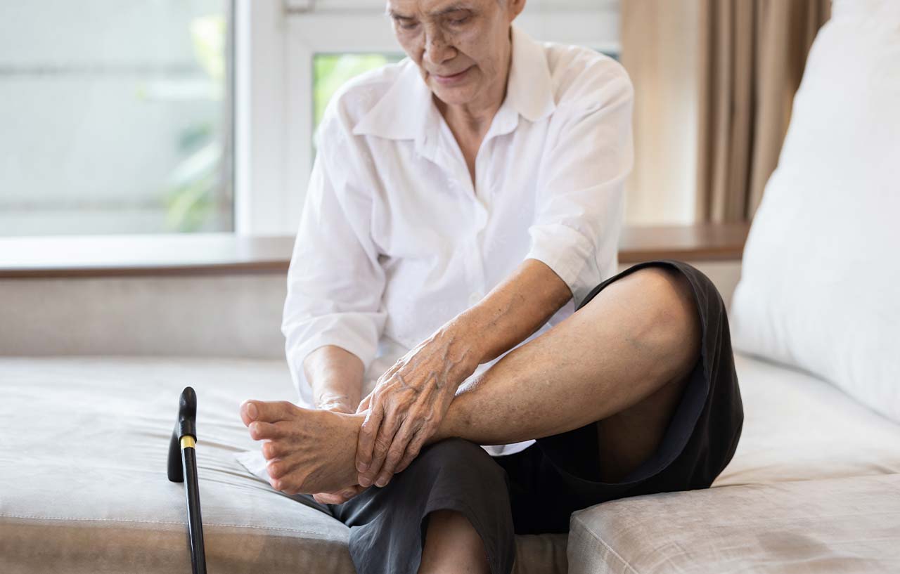 Woman massaging her foot to try and relieve her ankle pain