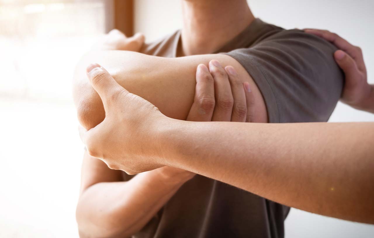 Surgeon checking a patient's arm movement for a sign that rotator cuff surgery may be required