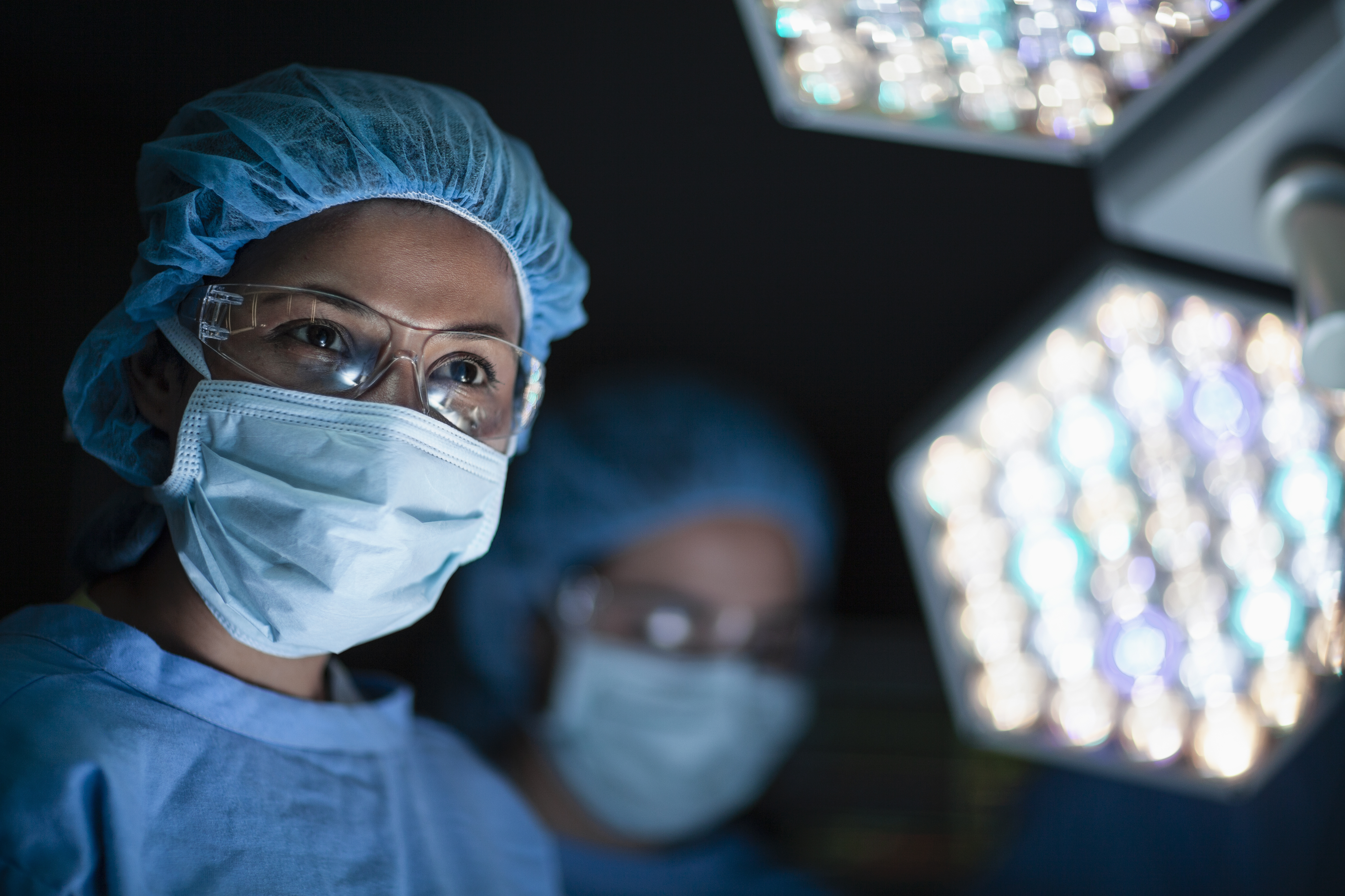 A medical doctor smiling at nurse in surgery operation room