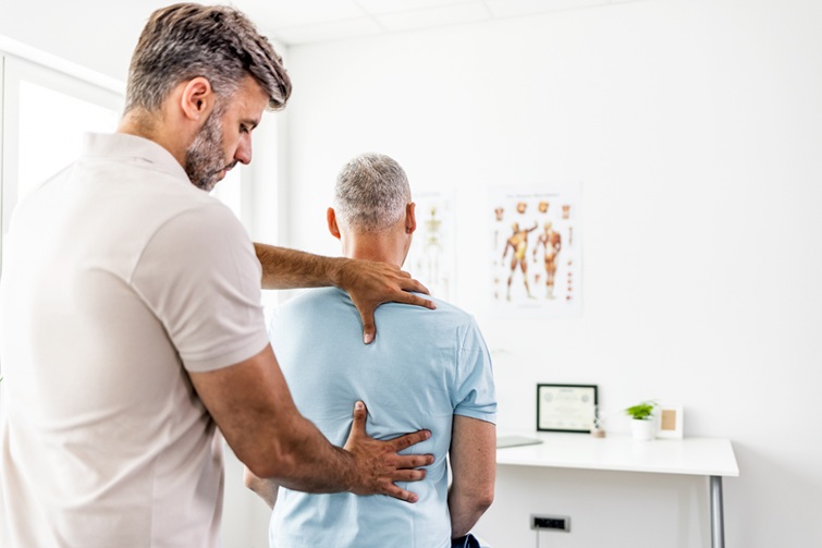 Spinal consultant examining private patient's spine