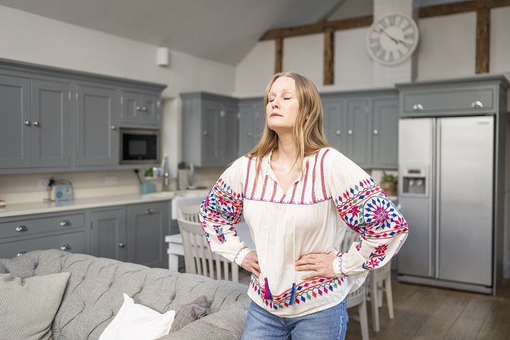 Woman holding her pelvis in pain needs pelvic health physiotherapy sessions