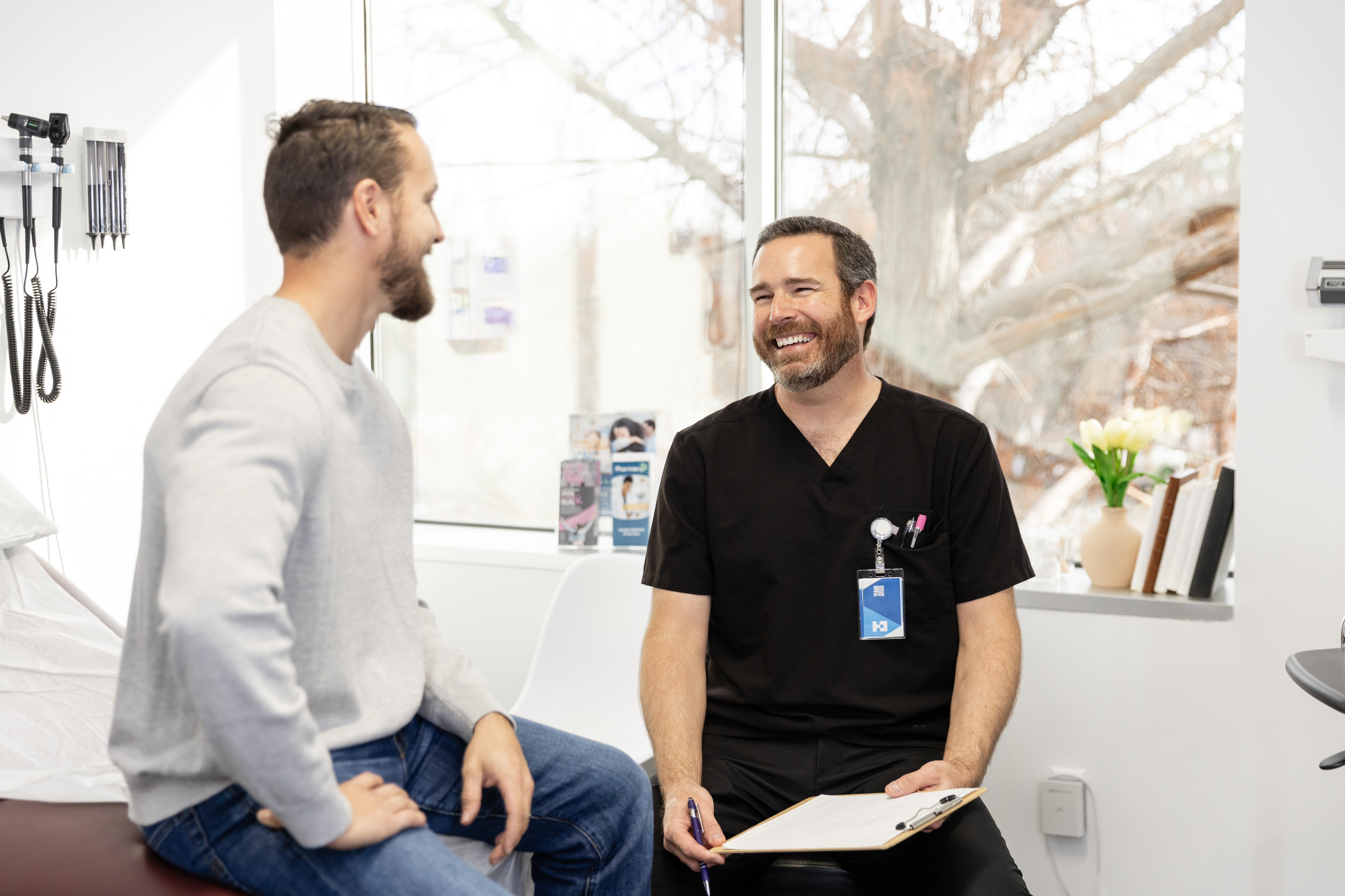 A smiling male patient talking to a male doctor 
