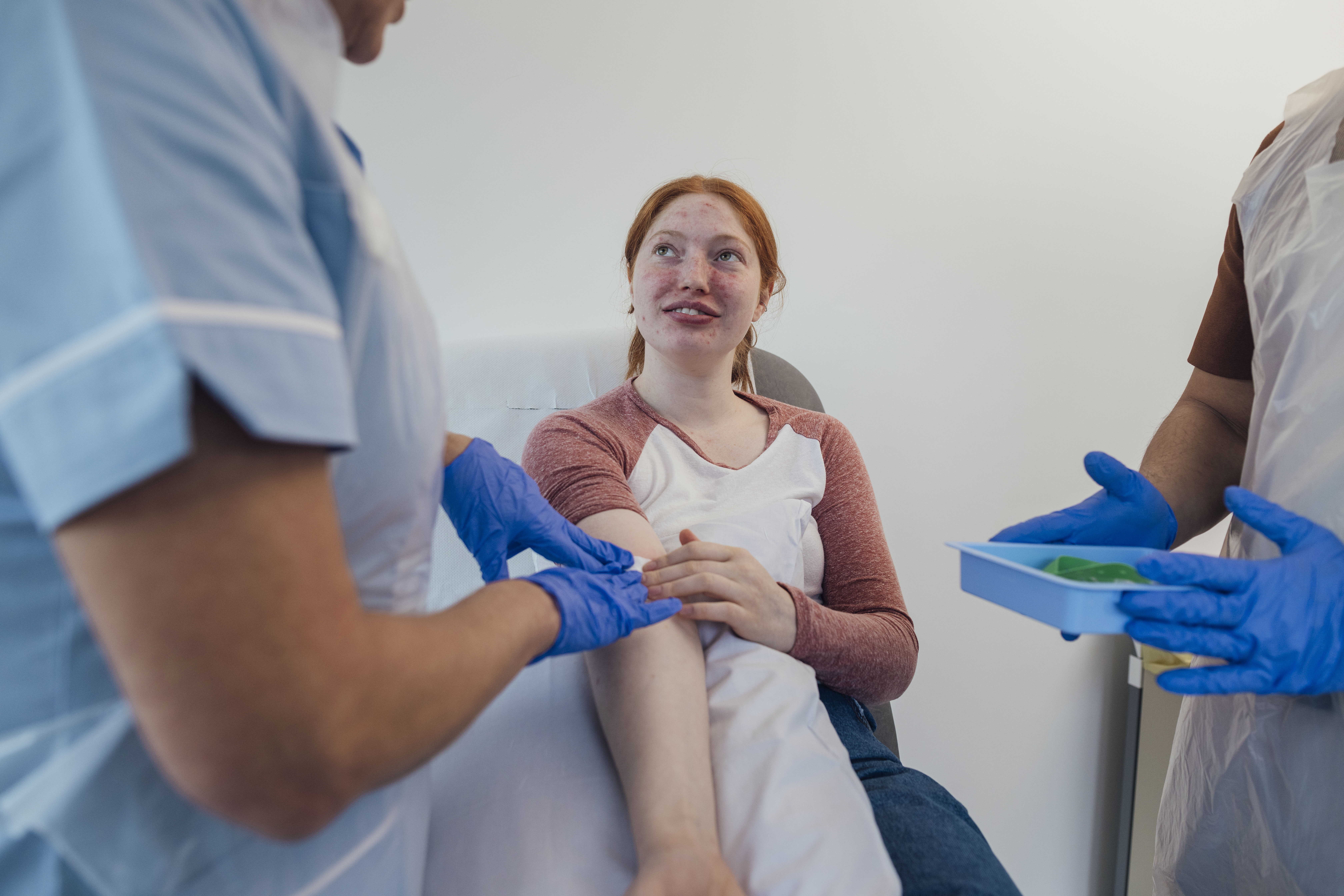 A young woman has a patch put on her arm