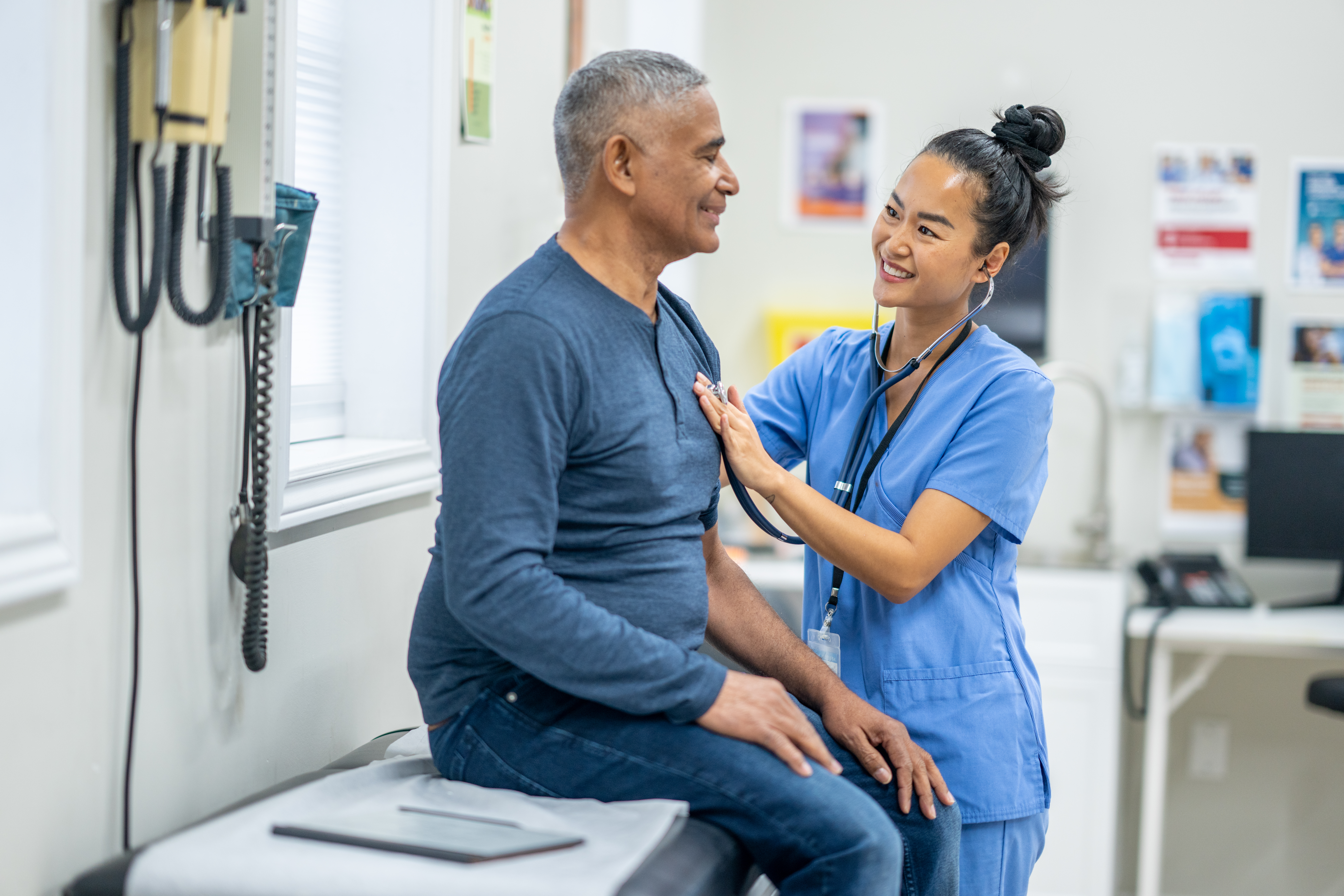 An elderly man being medically checked by a doctor