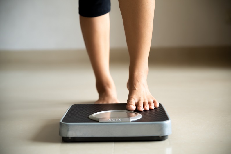 Patient checking weight on scales
