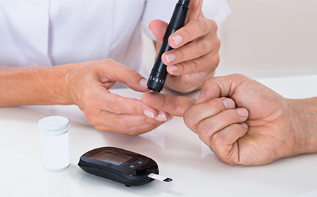 clinician taking diabetes test on patients finger