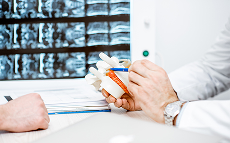 Close up of doctor describing hernia surgery with a medical model
