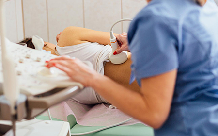 clinician performing ultrasound scan on patients kidneys