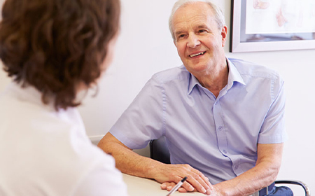 elder male patient in consultation with specialist