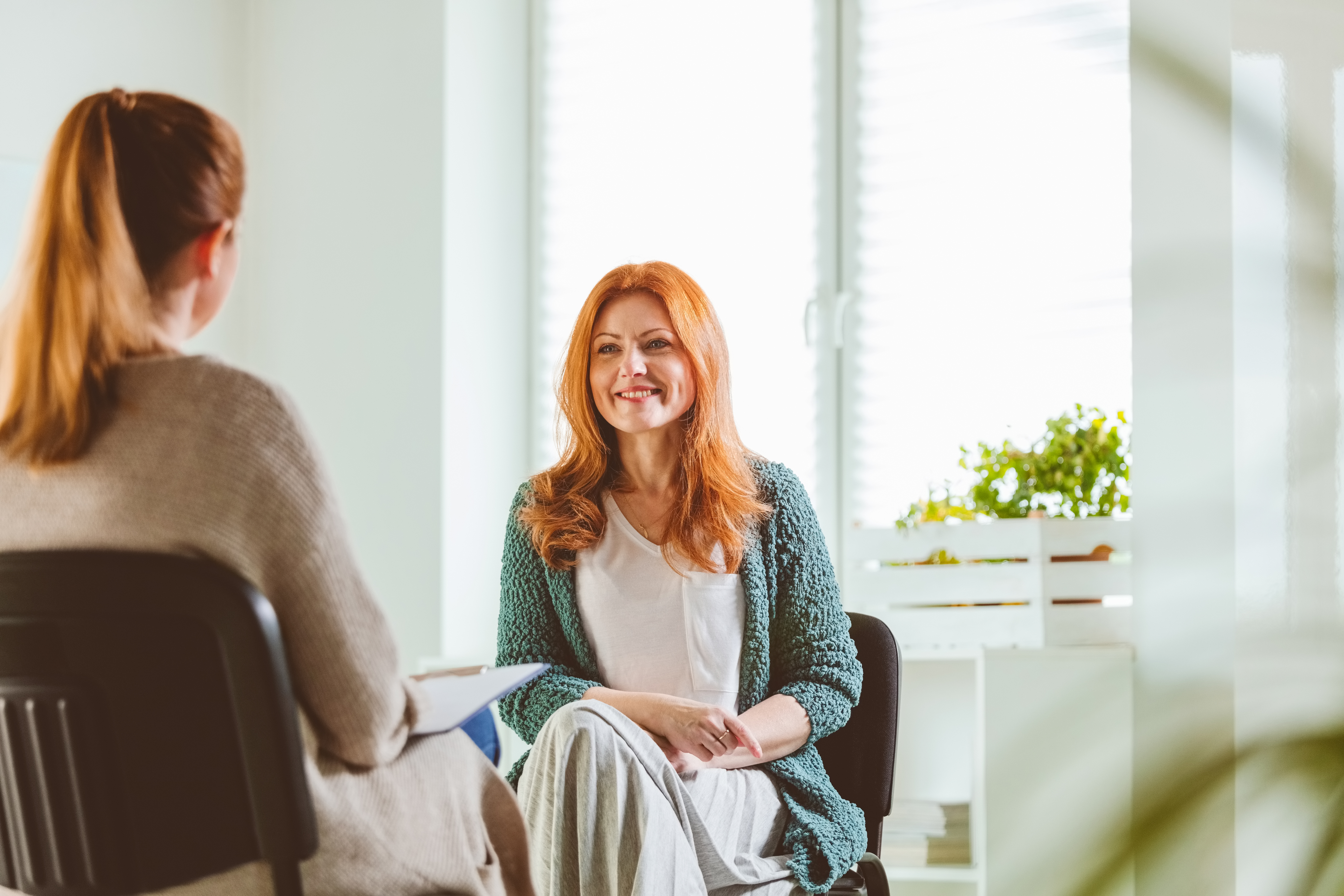 Smiling woman sat across from her therapist