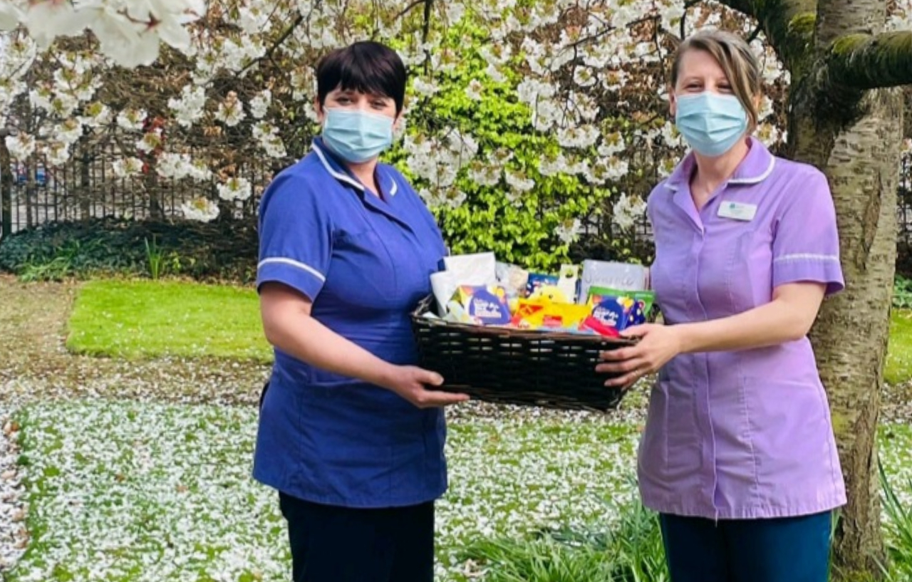 Two healthcare professionals hold an Easter basket